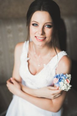 Beyaz elbiseli lüks gelin düğün törenine hazırlanırken poz veriyor.