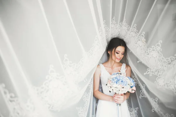 Gyönyörű menyasszony visel divat esküvői ruha tollak luxus öröm smink és frizura, stúdió beltéri fotózás — Stock Fotó
