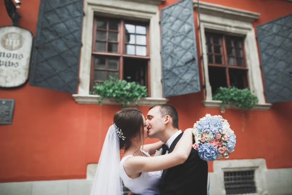 Розкішна подружня весільна пара, наречена і наречений позує в старому місті — стокове фото