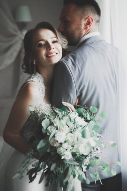 Gelin çiçekli büyük ve güzel bir düğün buketi tutuyor.