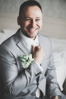 Güzel adam, damat poz veriyor ve düğüne hazırlanıyor.