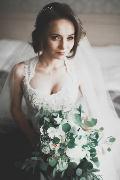 Linda noiva em roupão posando e se preparando para o rosto cerimônia de casamento em uma sala — Fotografia de Stock