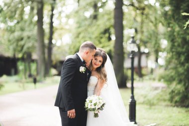 Güzel mutlu bir düğün çifti, uzun beyaz elbiseli gelin.