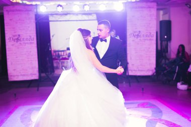 Güzel beyaz bir çift yeni evlendiler ve ilk danslarını ediyorlar.