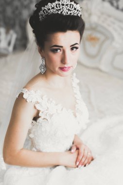Beyaz elbiseli lüks gelin düğün törenine hazırlanırken poz veriyor.