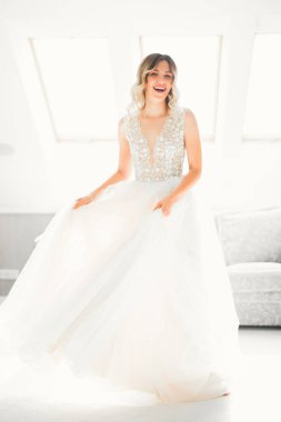 Beyaz elbiseli lüks gelin düğün törenine hazırlanırken poz veriyor.