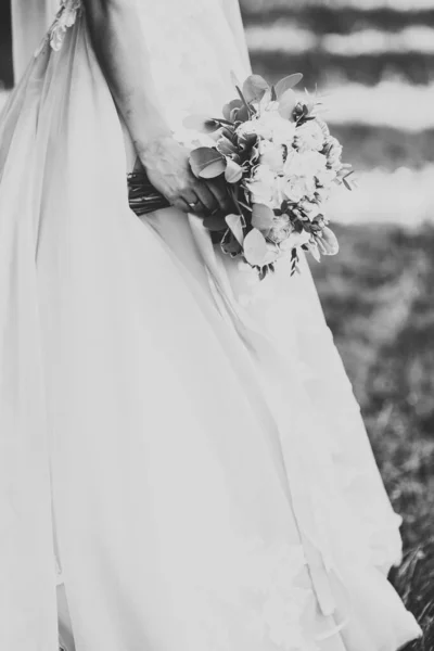 Krásná luxusní mladá nevěsta ve svatebních šatech pózuje v parku — Stock fotografie