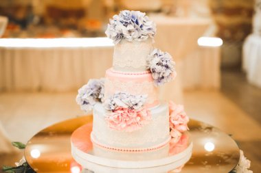 Masada süslü düğün pastası var.
