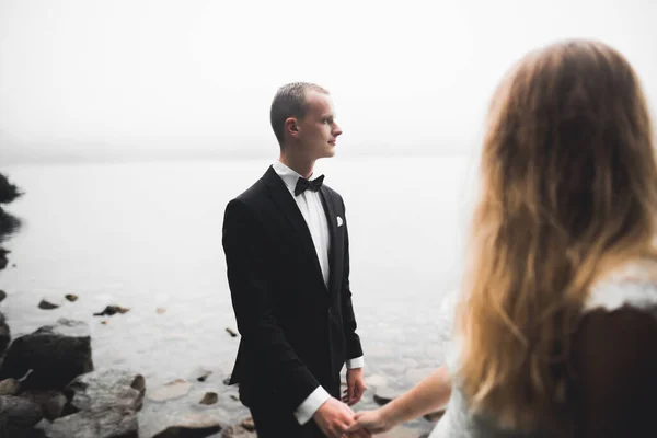 Scena felice e romantica di appena sposati giovani sposi in posa sulla bellissima spiaggia — Foto Stock