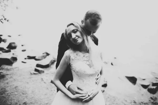 Feliz y romántica escena de recién casada joven pareja de boda posando en la hermosa playa —  Fotos de Stock