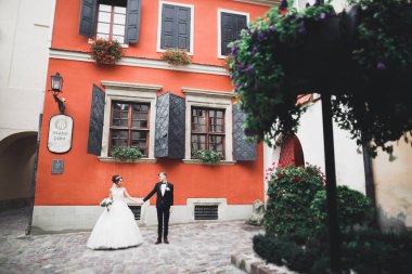 Çiçek buketi taşıyan mükemmel bir düğün çifti.