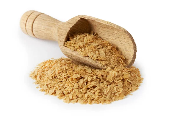 Beyaz arka plan üzerinde izole ahşap kepçe beslenme bira Maya flakes