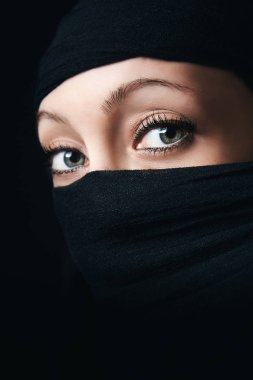 Tek gözlü görünür yakın kadın yüz, yüz geri kalan siyah eşarp ile kaplıdır