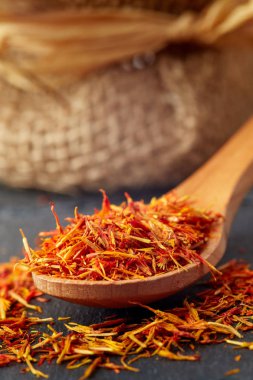 Aspir yaprakları siyah arka plan üzerine tahta kaşık (safran yerine)