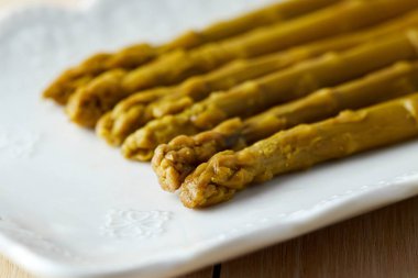 Beyaz tabak içinde servis turşu yeşil kuşkonmaz korunmuş