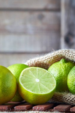 Ahşap arka plan üzerinde taze olgun organik limes. Kopya alanı