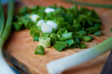 Rustik doğrama tahtasında yeşil soğan, bahar soğan veya salata soğan olarak da bilinen scallions,