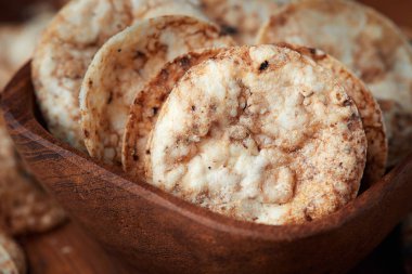 Tahta kasede kahverengi pirinç cipsi. Sağlıklı gevrek atıştırmalık