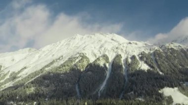 Bu video, gün boyunca karlı dağların üzerinden geçen bulutların hızlandırılmış görüntülerini içeriyor..