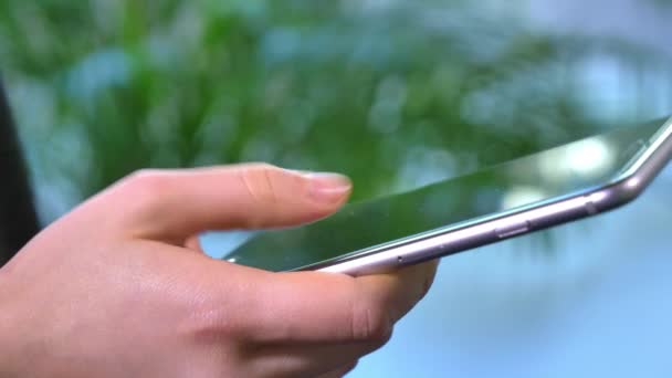 Cette vidéo montre une femme surfant sur Internet sur son smartphone. Utilisez-le pour des publicités, des documentaires et des reportages sur la technologie, les smartphones, Internet, les applications de médias sociaux, etc. .