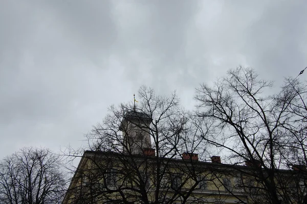 Um edifício antigo contra um céu escuro com nuvens — Fotografia de Stock