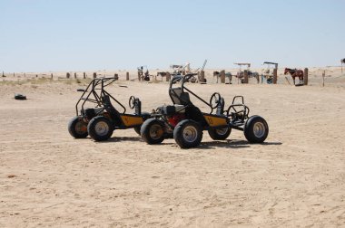 terk edilmiş bir araba kumun üzerinde duruyor