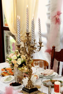 şenlikli masaya büyük gümüş mumlar ile şamdan