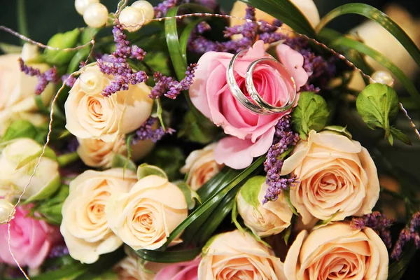 En brudbukett av känsliga blommor med vigselringar — Stockfoto