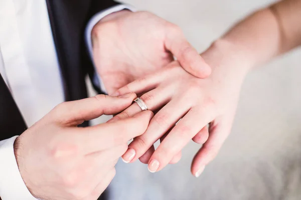 O noivo põe um anel de noivado de casamento à noiva no dedo — Fotografia de Stock