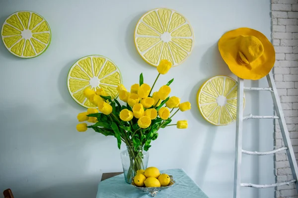 Yellow lemons and yellow tulips on the table — Stock Photo, Image