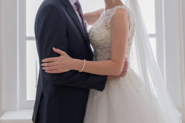 Gelin ve damat aydınlık salonda sarılma