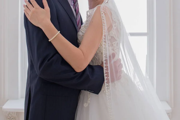 Νύφη και γαμπρός αγκάλιασμα στο φωτεινό δωμάτιο — Φωτογραφία Αρχείου