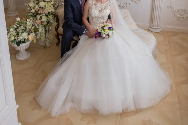 Невеста и жених садятся на диван — стоковое фото