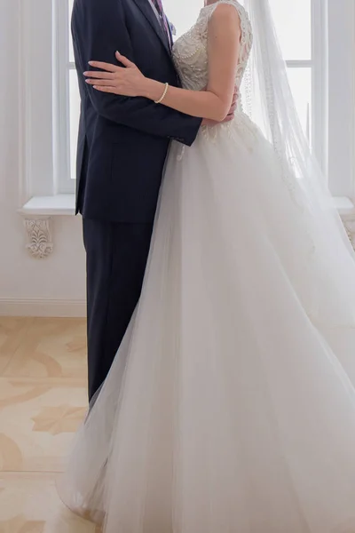 Bruid en bruidegom knuffelen in lichte kamer — Stockfoto