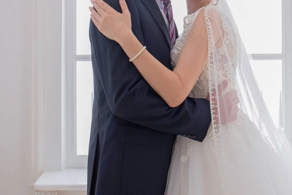 Nevěsta a ženich objímání ve světlé místnosti — Stock fotografie