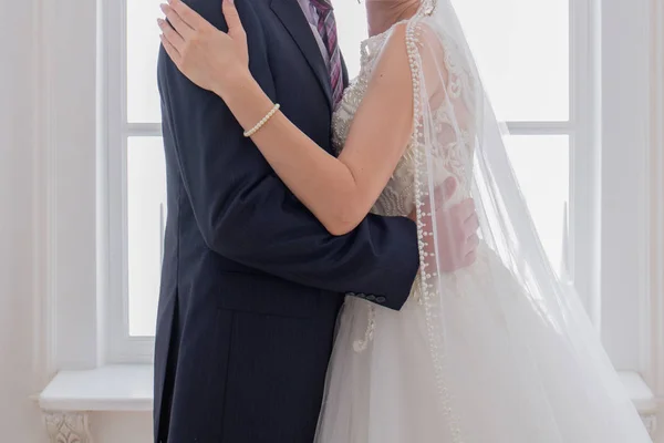 Νύφη και γαμπρός αγκάλιασμα στο φωτεινό δωμάτιο — Φωτογραφία Αρχείου