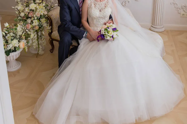 Bruden och brudgummen sitter på soffan — Stockfoto