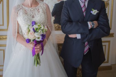 damat gelini parlak bir odada yanında duruyor