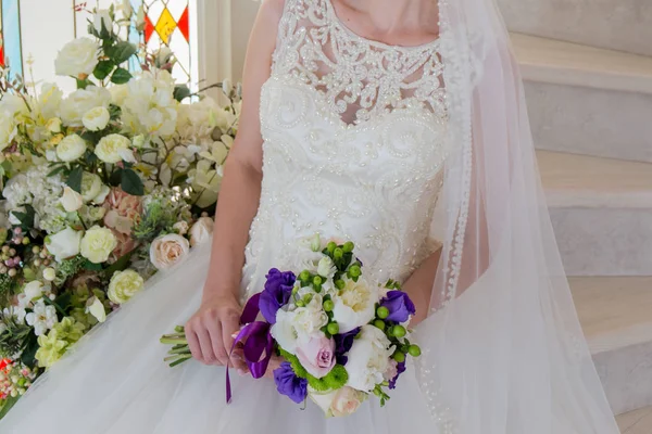 Pengantin sedang duduk di gaun pengantin dengan buket di tangan — Stok Foto