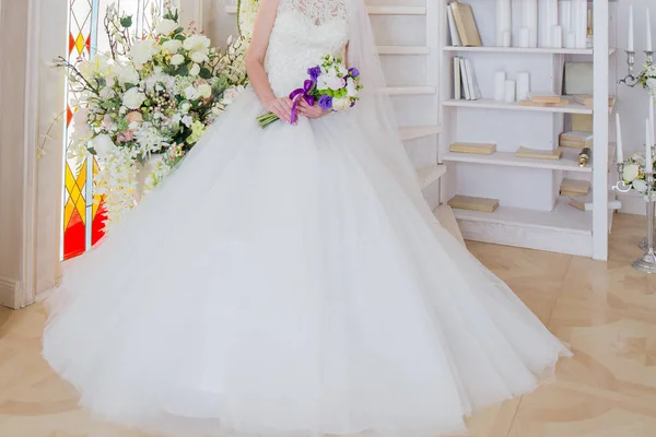 The bride is sitting in a wedding dress with a bouquet in hand — Stock Photo, Image