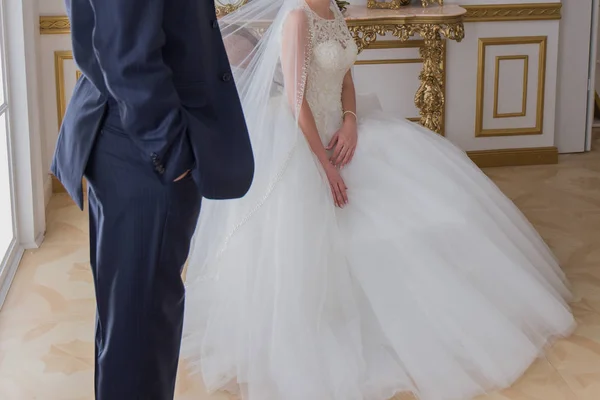 The groom stands next to the bride in a bright room — Stock Photo, Image