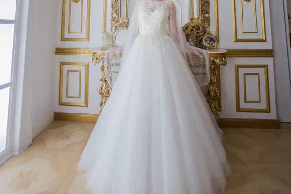 Νύφη στο γάμο φόρεμα στέκεται κοντά στον καθρέφτη — Φωτογραφία Αρχείου