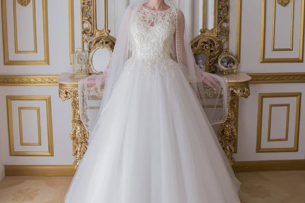 Nevěsta ve svatebních šatech stojí u zrcadla — Stock fotografie