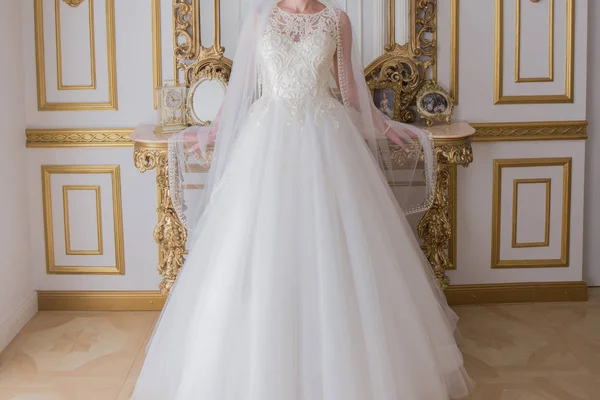 Bride in wedding dress is standing near the mirror — Stock Photo, Image