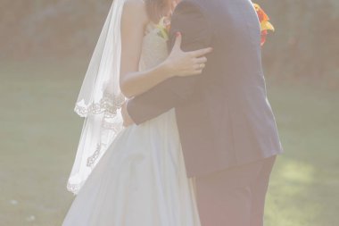 Gelin ve damat sonbahar çimleri üzerinde birlikte