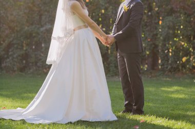 Gelin ve damat sonbahar çimleri üzerinde birlikte