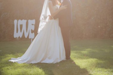 Gelin ve damat sonbahar çimleri üzerinde birlikte