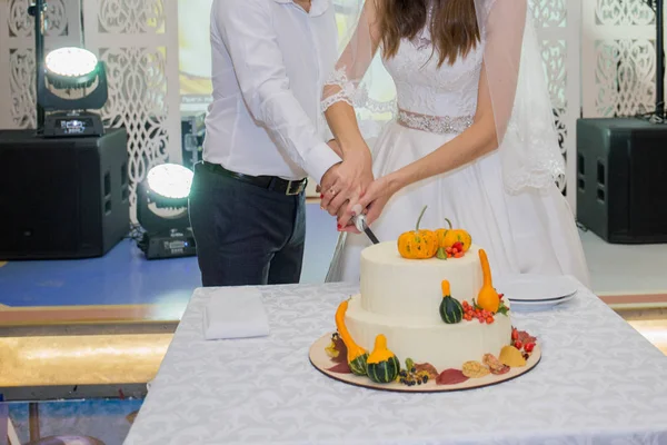 Νύφη και γαμπρός Κόψτε την γαμήλια τούρτα στο τραπέζι — Φωτογραφία Αρχείου