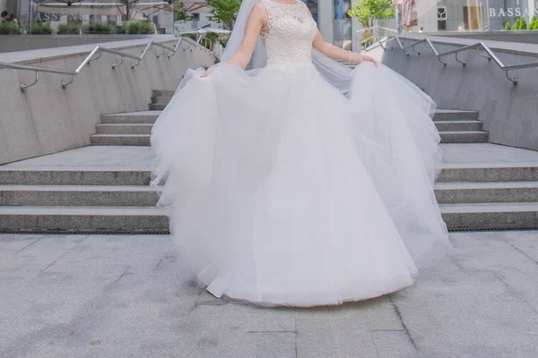La novia en un vestido de novia gira en las escaleras — Foto de Stock