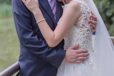 Gelin ve damat stand bahçede sarılma.